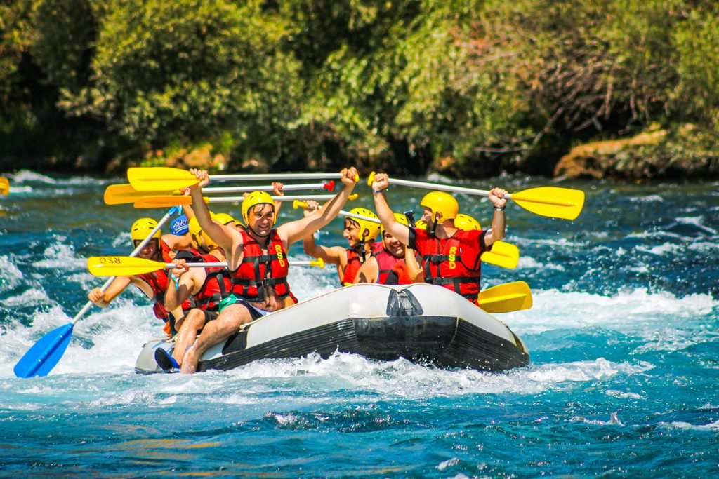 Grupo de amigos haciendo rafting durante una actividad de aventura