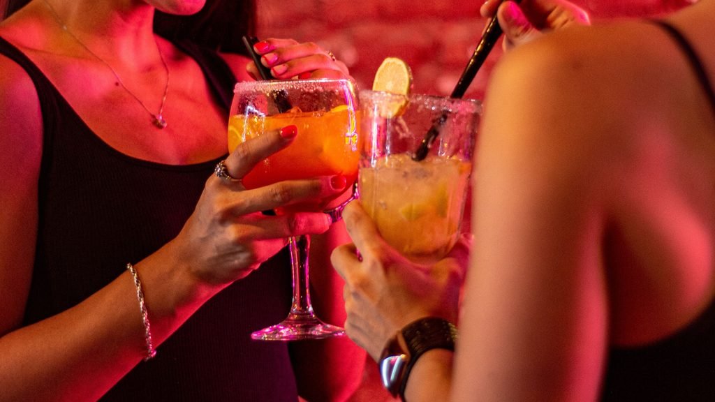 Dos amigas disfrutando de una bebida durante una fiesta de despedida