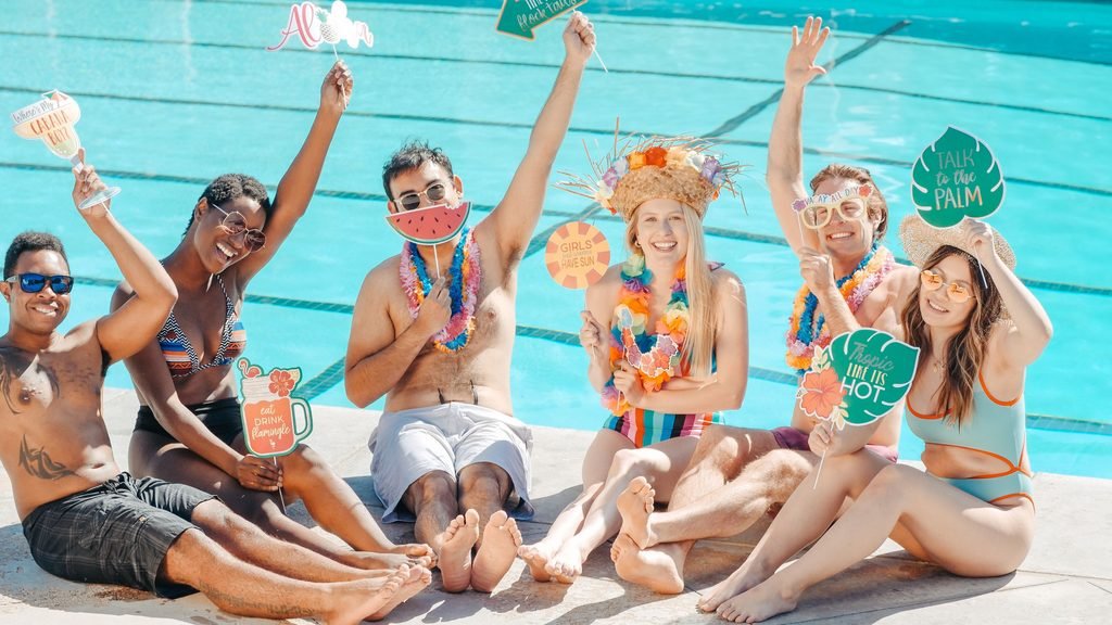 Grupo de amigos disfrutando de una fiesta hawaiana durante una despedida LGTBI