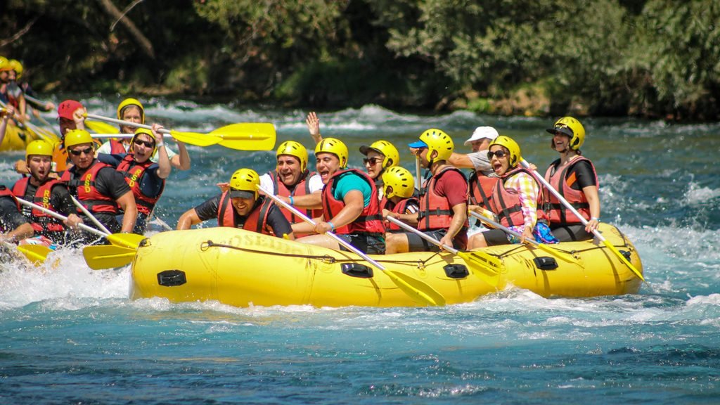 Grupo de amigos y amigas haciendo rafting durante una despedida mixta