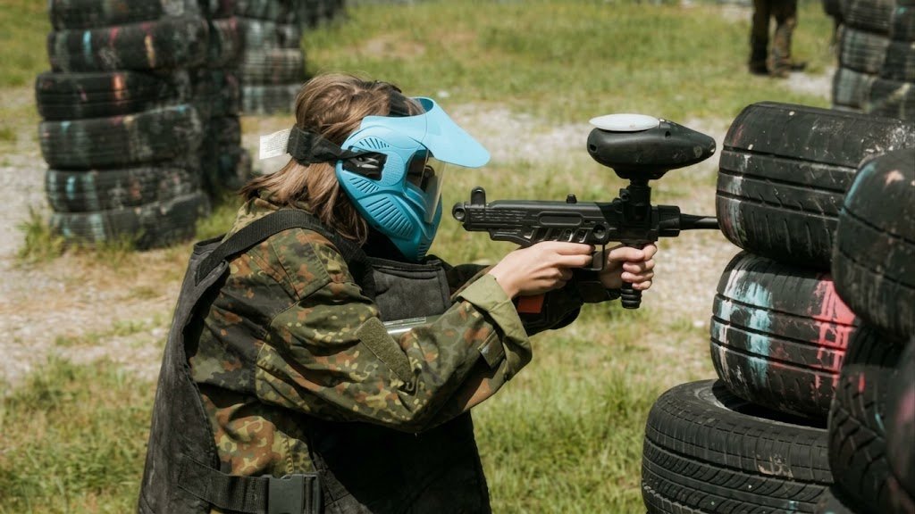Chica jugando al paintball durante una despedida de soltera lesbiana