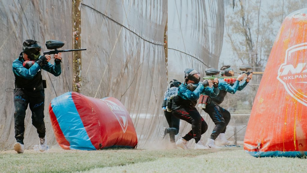Grupo de amigos jugando al paintball durante una despedida