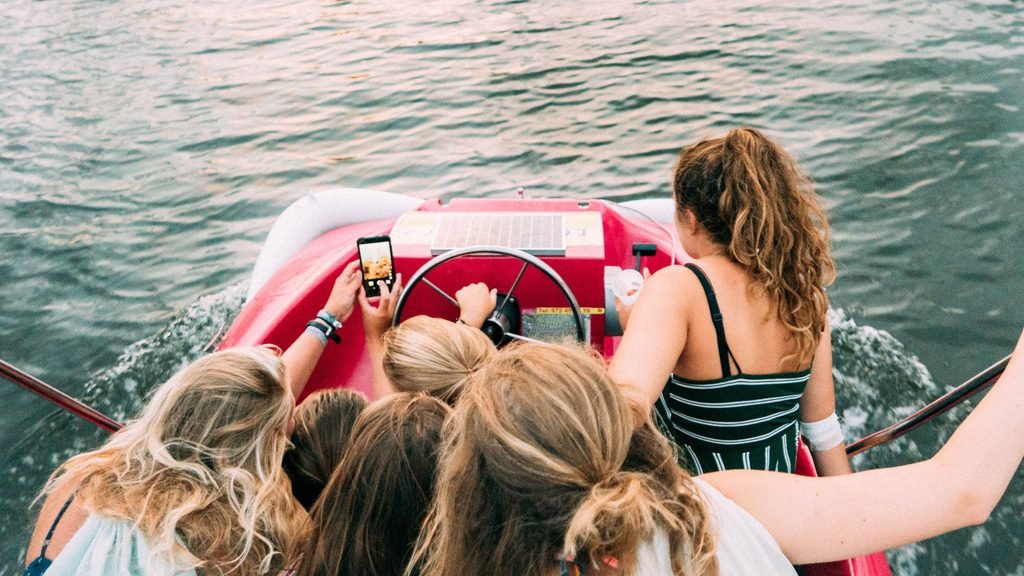 Grupo de amigas disfrutando de un paseo en barco durante una despedida