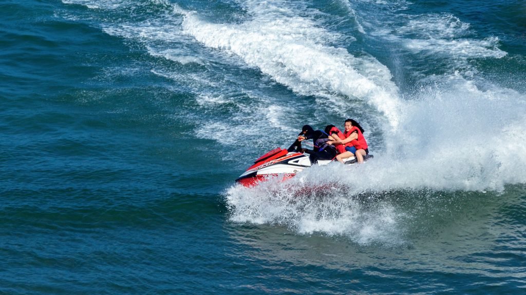 Grupo de amigos disfrutando de motos de agua durante una despedida